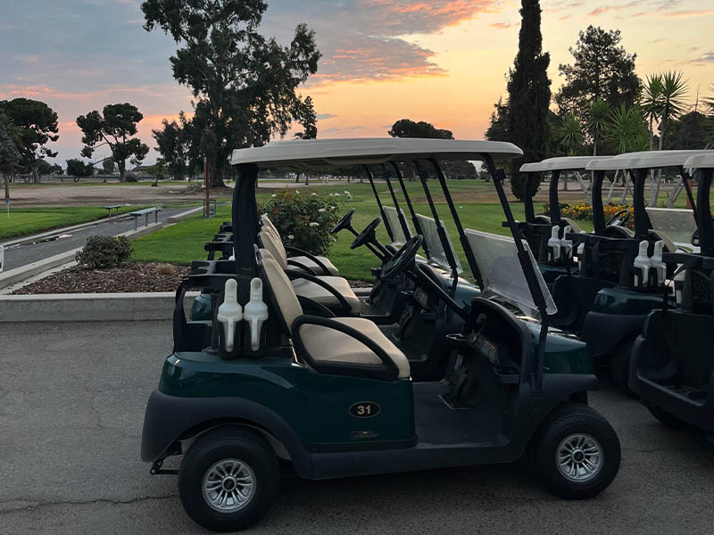 Golf carts lined up near the course at sunset at Airways Golf Course in Fresno.